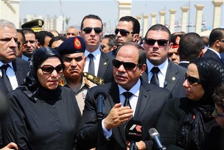 In this picture taken Tuesday, June 30, 2015, provided by the office of the Egyptian Presidency, Egyptian president Abdel-Fattah el-Sissi, center, speaks at the funeral for Hisham Barakat, surrounded by his family members, the top judicial official in charge of overseeing the prosecution of thousands of Islamists, including former President Mohammed Morsi. AP