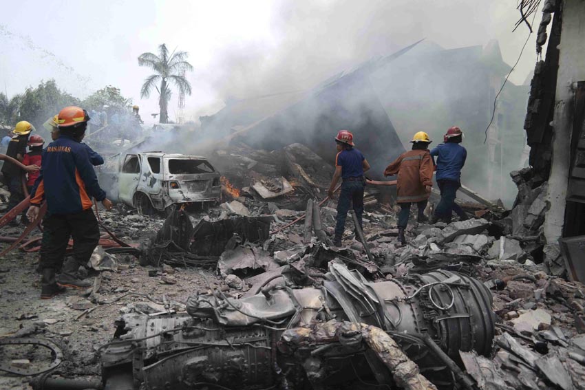 Firemen attempt to extinguish the fire surrounding the wreckage of an Indonesian military transport plane after it crashed in the North Sumatra city of Medan, Indonesia, June 30, 2015 in this photo taken by Antara Foto. 
