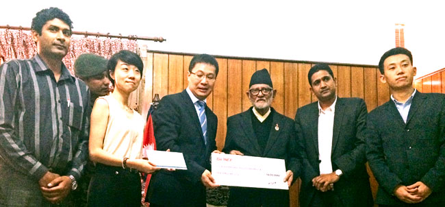 Prime Minister Koirala (c) receiving a cheque of Rs 5 million provided by Syntech Hong Kong Technology Ltd, China to support the earthquake victims, in Kathmandu on Tuesday, June 30, 2015. PMu2019s Secretariat