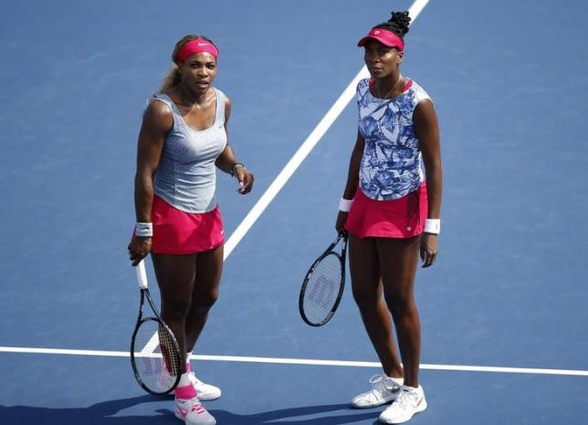 Serena Williams (L) and Venus Williams of the U.S. talk during their doubles match against Garbine Muguruza and Carla Suarez Navarro of Spain during their match at the 2014 U.S. Open tennis tournament in New York, August 31, 2014. Photo: Reuters