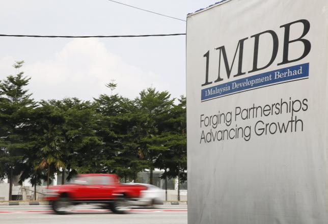 Traffic passes a 1Malaysia Development Berhad (1MDB) billboard at the Tun Razak Exchange development in Kuala Lumpur, Malaysia, July 6, 2015. REUTERS/Olivia Harris