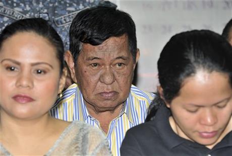 FILE - In this Monday March 26, 2012, file photo, Andal Ampatuan Sr., center, a powerful Filipino clan leader who is a suspect in the 2009 massacre of 57 people, listens during his arraignment on electoral sabotage at the Pasay city regional trial court, south of Manila, Philippines. Ampatuan's lawyer, Salvador Panelo says his client died overnight on Friday, July 17, 2015, in a government hospital. Ampatuan was brought to the National Kidney and Transplant Institute in early June and was diagnosed with liver cancer. AP
