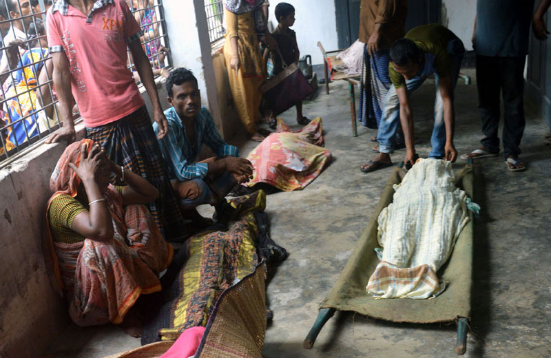  Bangladeshi relatives react as they sit near the bodies of some of those killed in a stampede at a charity distribution event in Mymensingh on July 10 , 2015.  Photo: AFP