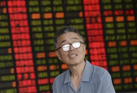 A stock investor looks up in a brokerage house in Shanghai Friday July 3, 2015. China cut the number of initial public offerings planned this month by two-thirds on Friday, adding to frantic efforts to shore up plunging stock prices following another 5.7 percent decline in the country's main market index. AP