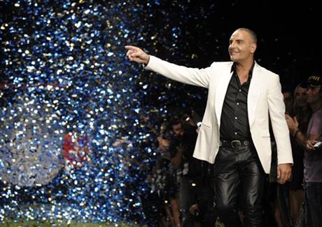 FILE - In this Oct. 15, 2008 file photo, designer Christian Audigier gestures to the crowd after his Christian Audigier Presents American Lord show during Mercedes-Benz fashion week in Culver City, Calif. AP