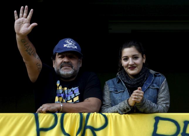 Former Argentine soccer player Diego Maradona waves from a balcony next to his daughter Jana as they attend the Argentine First Division soccer match between Boca Juniors and Quilmes at La Bombonera stadium in Buenos Aires July 18, 2015.   REUTERS/Marcos Brindicci
