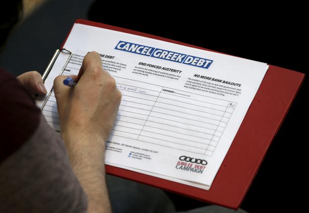 A man adds his name to a petition to cancel Greek debt during a rally in support of Greece at the TUC's Congress House, in London, Britain, July 6, 2015.  REUTERS/Peter Nicholls