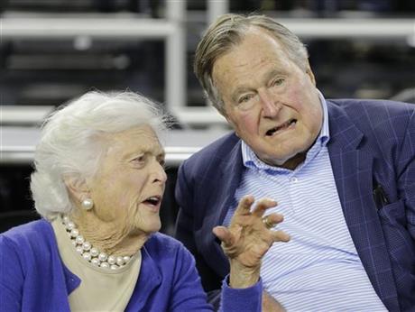FILE- In this March 29, 2015, file photo, former President George H.W. Bush and his wife Barbara Bush speak before the first half of an NCAAA college basketball game in Houston. AP
