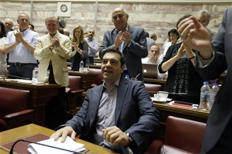 Greece's Prime Minister Alexis Tsipras arrives for a meeting as his lawmakers of Syriza party applaud him at the Greek Parliament in Athens, Friday, July 10, 2015. Tsipras will seek backing for a harsh new austerity package from his party Friday to keep his country in the euro u2014 less than a week after urging Greeks to reject milder cuts in a referendum. AP