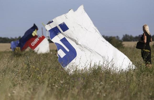 A woman takes a photograph of wreckage at the crash site of Malaysia Airlines Flight MH17 near the village of Hrabove (Grabovo), Donetsk region July 26, 2014. REUTERS/Sergei Karpukhin