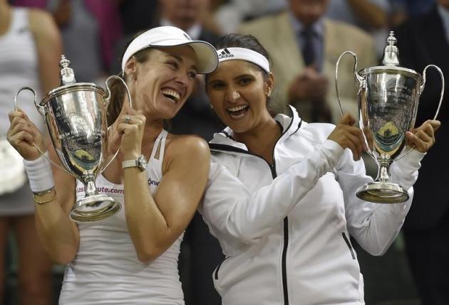 Martina Hingis of Switzerland and Sania Mirza of India pose with their trophies after winning their Women's Doubles Final match against Elena Vesnina and Ekaterina Makarova of Russia at the Wimbledon Tennis Championships in London, July 11, 2015.                                                  REUTERS/Toby Melville