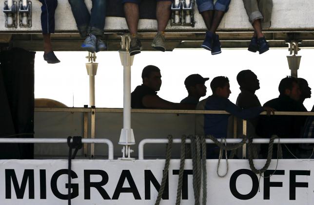 Migrants wait to disembark from the Migrant Offshore Aid Station (MOAS) ship MV Phoenix in the Sicilian harbour of Messina, Italy July 15, 2015. REUTERS/Antonio Parrinello   TPX IMAGES OF THE DAY