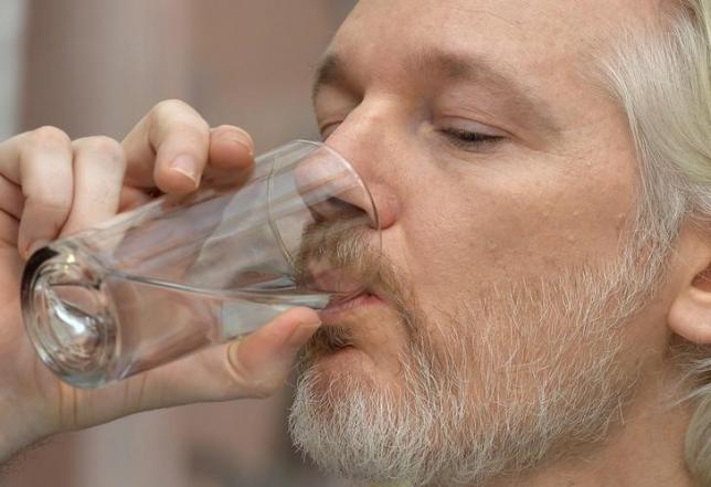 WikiLeaks founder Julian Assange has a drink of water during a news conference at the Ecuadorian embassy in central London August 18, 2014.  REUTERS/John Stillwell/pool/Files