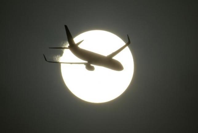 An aircraft is silhouetted by the sun in New Delhi June 13, 2011. REUTERS/B Mathur/Files
