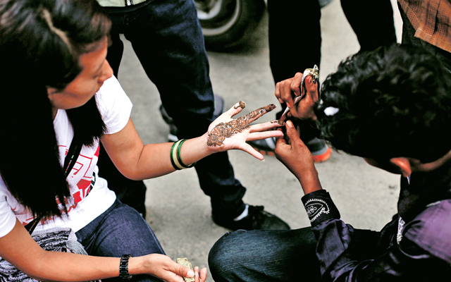 A man applying mehndi on the hand of a girl, in New Road, Kathmandu, on Thursday. Photo: THT