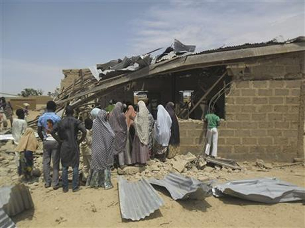 People gather at the site of suicide bomb attack at Redeem Christian church in Potiskum, Nigeria, Sunday, July 5, 2015. Witnesses say a woman suicide bomber blew up in the midst of a crowded evangelical Christian church service on Sunday and killed at least five people, the latest in a string of bombings and shooting attacks blamed on the Islamic extremist group Boko Haram that has killed some 200 people in the past week. Photo: Ap