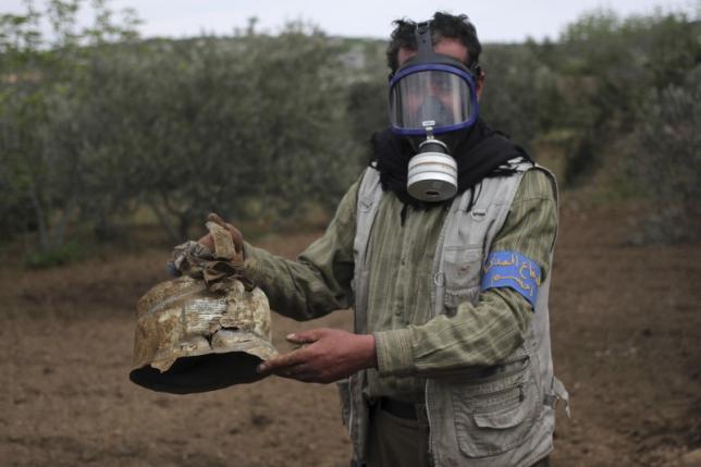 A Civil Defence member carries a damaged canister in Ibleen village from what activists said was a chlorine gas attack, on Kansafra, Ibleen and Josef villages, Idlib countryside May 3, 2015. REUTERS/Abed Kontar