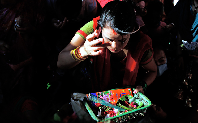 A devotee talking on mobile phone as she stands in line to offer prayers to Lord GAnesh, in Chabahil Ganeshthan, on Tuesday. Photo: THT