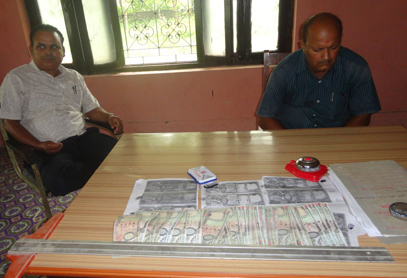 Accused engineers Ishwari Prasad and Mishra with the bribe money on Sunday. Photo: Shreeram Sigdel