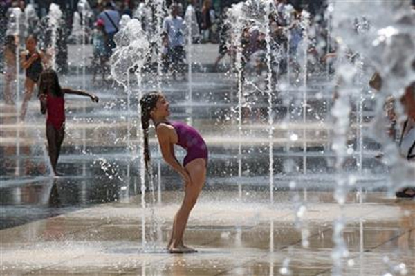 Children cool off in the water fountains in Nice, southeastern France, Sunday, July 5, 2015. A mass of hot air moving north from Africa is bringing unusually hot weather to Western Europe, with France in recent days experiencing temperatures around 34 degrees Celsius. Photo: AP