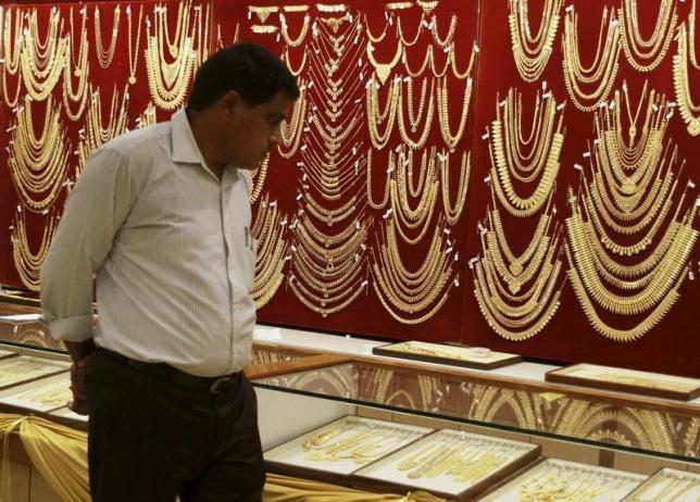 A customer looks at gold ornaments on display inside a jewelry showroom on the occasion of Akshaya Tritiya, a major gold buying festival, in the southern Indian city of Kochi April 21, 2015. REUTERS/Sivaram V
