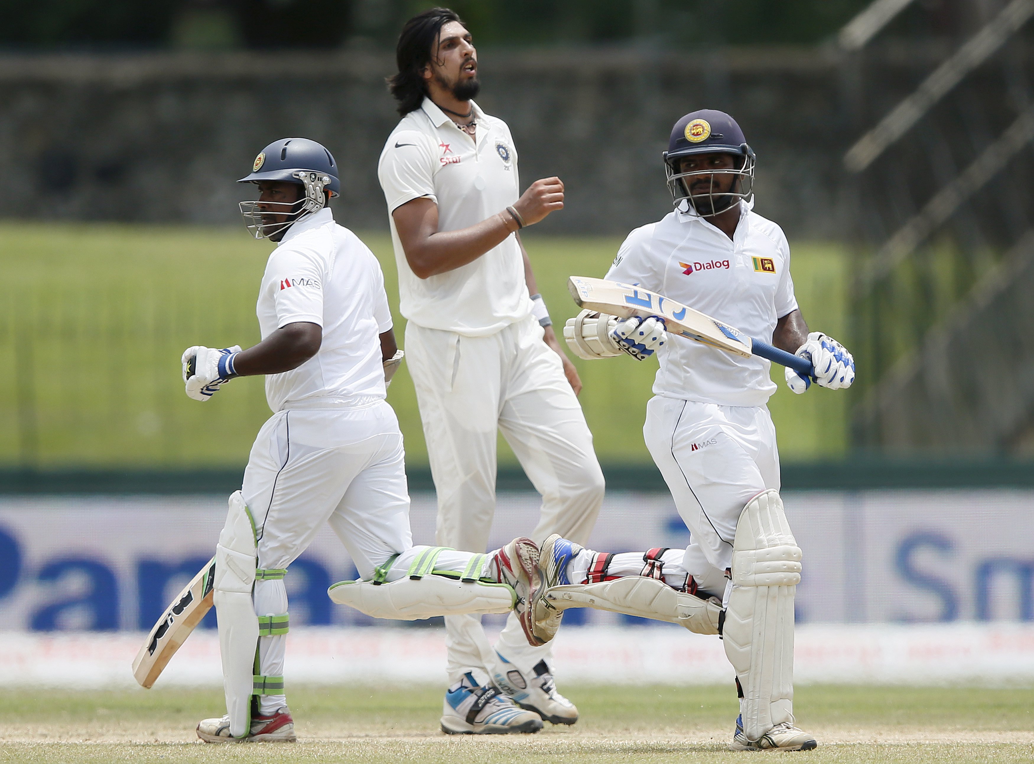     Sri Lanka's Rangana Herath (left) and Kusal Perera (right) run between wickets next to India's Ishant Sharma during the third day of their third and final test cricket match in Colombo, August 30, 2015. Photo: REUTERS