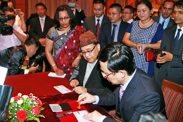 Information Secretary Sunil Bahadur Malla (left) and Chinese Ambassador Wu Chuntai putting issuing a postage stamp to mark the 60th anniversary of Nepal-China relations, in Kathmandu, on Saturday.  Photo:RSS