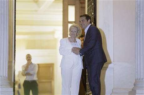Outgoing Prime Minister Alexis Tsipras, right, shakes hands with Greece's new Prime Minister Vassiliki Thanou, after a handover ceremony as he leaves the Maximou mansion in Athens, on Thursday, Aug. 27, 2015. AP