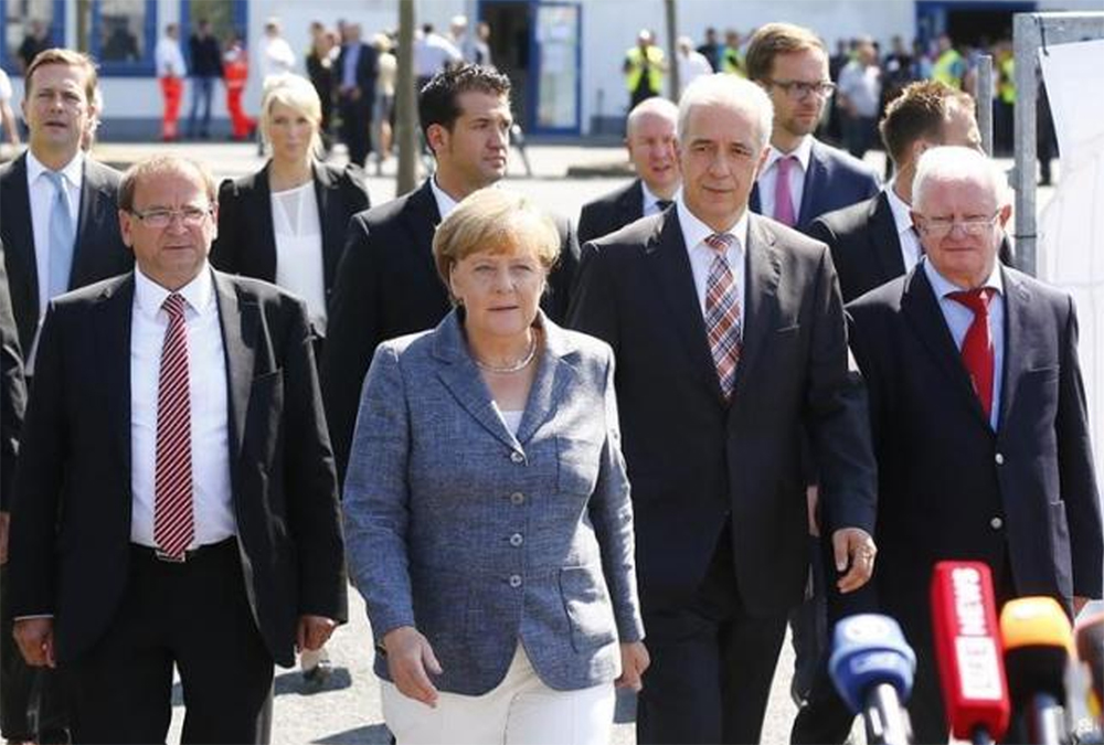 Heidenau major Juergen Opitz, German Chancellor Angela Merkel, Saxony State Prime Minister Stanislaw Tillich and President of the German Red Cross Rudolf Seiters (LtoR) arrive for statements after their visit to an asylum seekers accomodation facility in the eastern German...Photo: Reuters