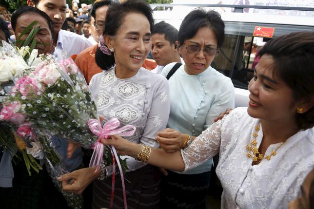 Myanmar pro-democracy leader Aung San Suu Kyi receives flowers from her supporters as she arrive to gives a speech on voter education at the Thanlyin township, outside Yangon August 21, 2015. REUTERS/Soe Zeya Tun