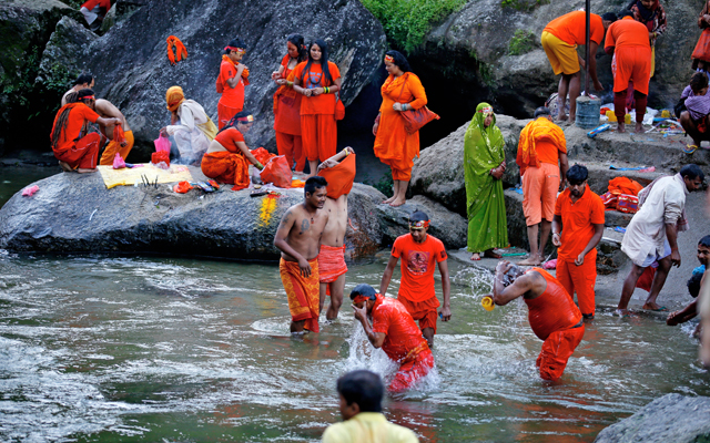 Bolbom Tirtha Yatra members taking a dip in the Sundarijal Naagmati River to conclude the month-long Shrawan festivities, in Kathmandu, on Monday. Photo: THT