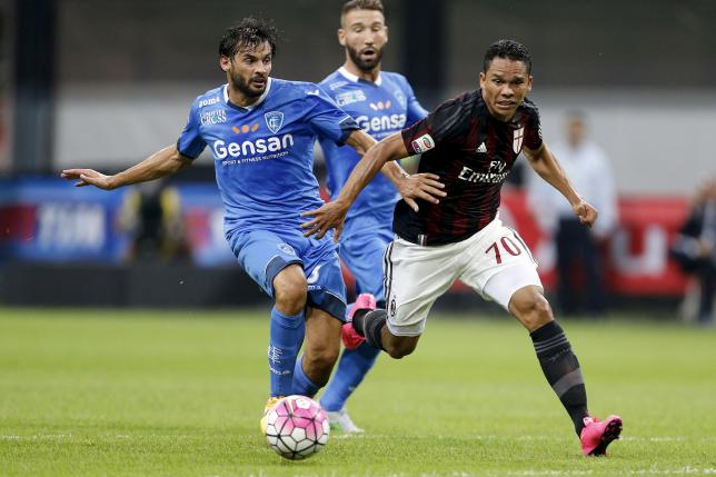 AC Milan's Carlos Bacca (R) and Empoli's Marco Zambelli fight for the ball during their Serie A soccer match at San Siro stadium in Milan, August 29, 2015. REUTERS/Giampiero Sposito
