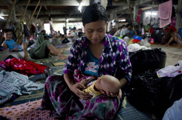 Flood-hit resident tends to her one-month old daughter at an evacuation camp in Kalay, nupper Myanmar's Sagaing region, on Sunday. Photo:AFP