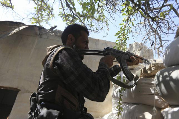 A fighter from the Free Syrian Army's Al Rahman legion fires his weapon on the frontline against the forces of Syria's President Bashar al-Assad in Jobar, a suburb of Damascus, Syria July 27, 2015.