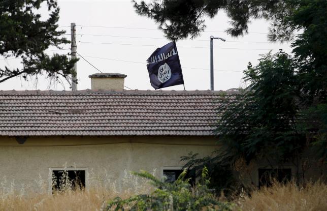 An Islamic State flag flies over the custom office of Syria's Jarablus border gate as it is pictured from the Turkish town of Karkamis, in Gaziantep province, Turkey August 1, 2015. REUTERS/Murad Sezer