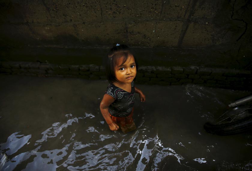 A girl walks through floodwaters caused by the heavy rainfall flowing from the swollen Bagmati River, which entered a slum in Kathmandu, Nepal August 17, 2015. REUTERS/Navesh Chitrakar