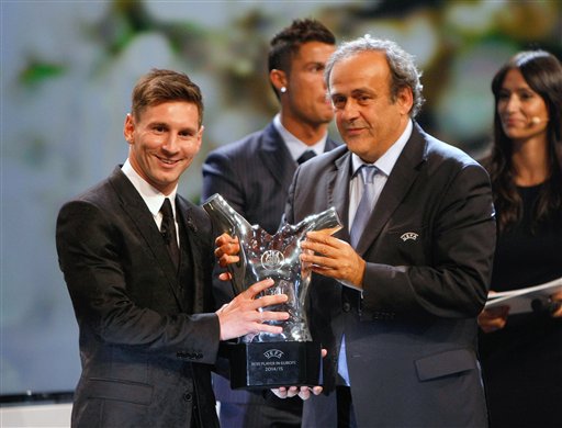 UEFA President Michel Platini, right, gives the trophy for best  player of the year to Barcelona's Lionel Messi of Argentina, during the UEFA Champions League draw at the Grimaldi Forum, in Monaco, Thursday, Aug. 27, 2015. (AP Photo/Claude Paris)