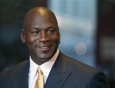 Michael Jordan smiles at reporters after a jury ordered a defunct grocery store chain to pay him $8.9 million for using his name without permission. Friday, Aug. 21, 2015, in Chicago. AP