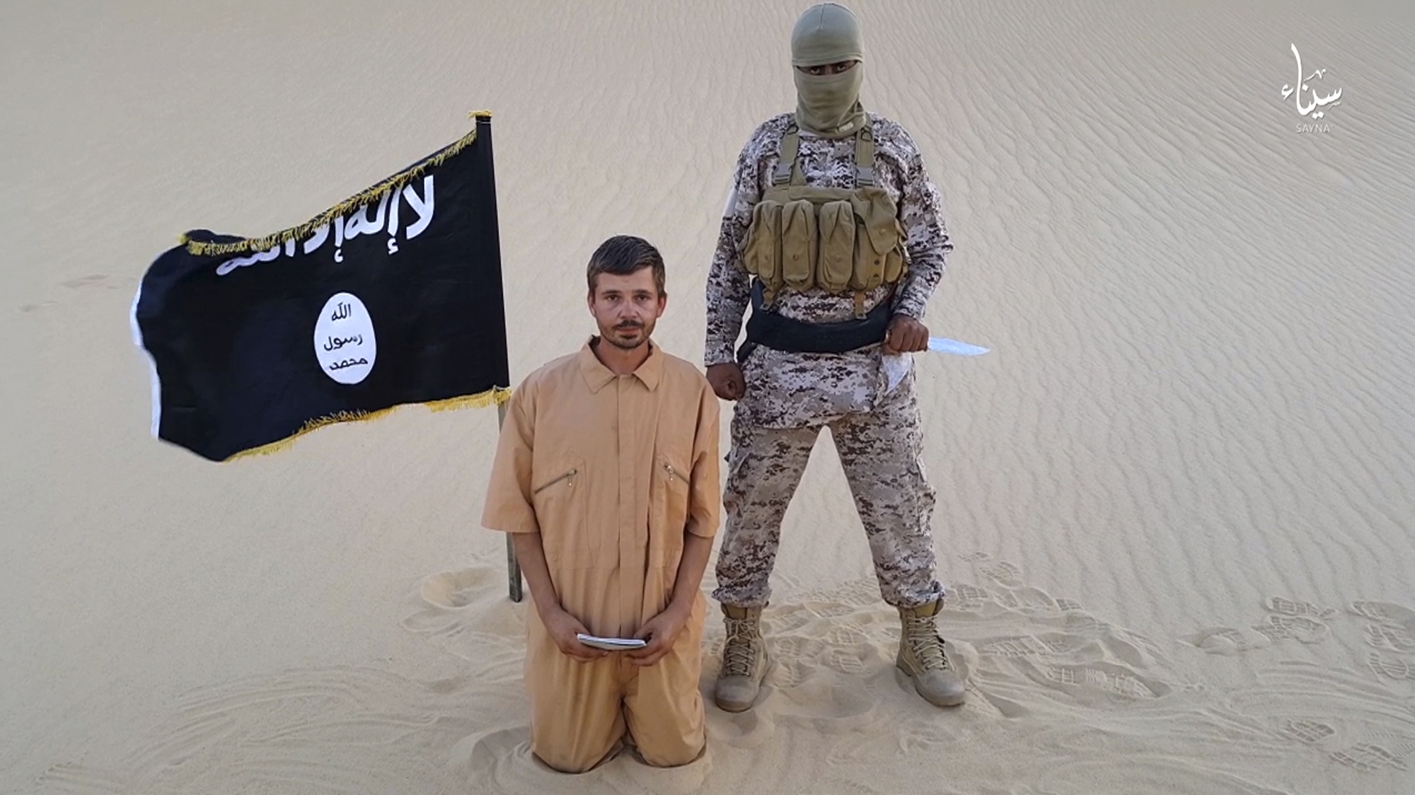 FILE - This image made from a militant video posted on a social media site on Wednesday, Aug. 5, 2015, which has been verified and is consistent with other AP reporting, purports to show a militant standing next to another man who identifies himself as 30-year-old Tomislav Salopek, kneeling down as he reads a message at an unknown location. An online image purports to show the Croatian hostage being held by an Islamic State affiliate in Egypt has been beheaded.