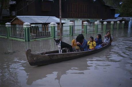 In this Aug. 3, 2015, photo, residents make their way through floodwaters in Minbu, Magway division, in Myanmar. The Ministry of Social Welfare, Relief and Resettlement said that more than 200,000 people are affected in 11 of the country's 14 states and divisions by flooding. AP