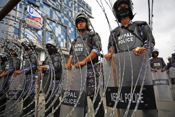 Nepal Police personnel standing behind a barricade during a protest by activists affiliated to Dalit organisations, who have been demanding nproportional representation in the central and provincial governments and legislature, in New Baneshwor, Kathmandu, on Wednesday.nPhoto:Skanda Gautam/THT