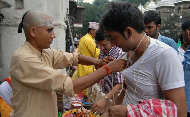 A man changing the sacred thread janai (white cotton string worn across the chest) at Pashupatinath Temple in the Capital on Sunday, August 10, 2014. Photo: THT file