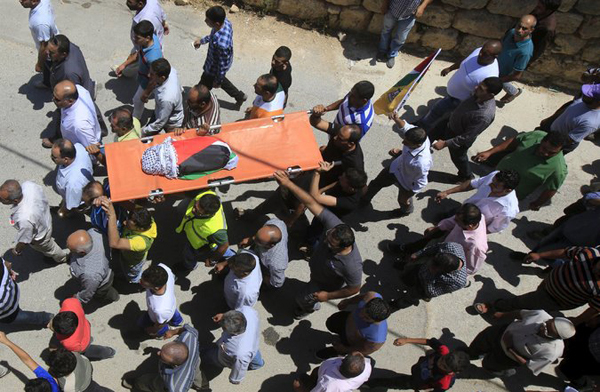 Mourners carry the body of an 18-month-old Palestinian baby Ali Dawabsheh, who was killed after his family's house was torched in a suspected attack by Jewish extremists in Duma village near the West Bank city of Nablus, on Friday. Photo: AP