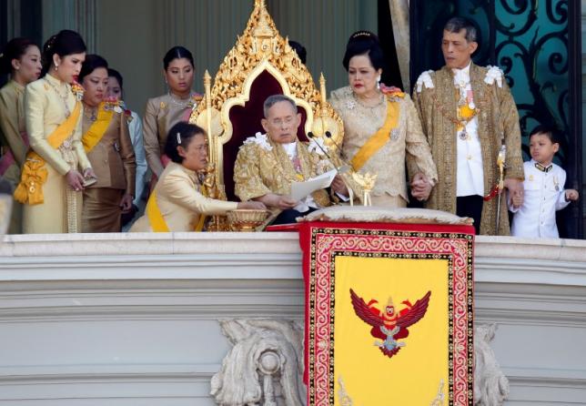 Princess Maha Chakri Sirindhorn assists Thailand's King Bhumibol Adulyadej (C) as he delivers his birthday speech from the balcony of the Grand Palace together with Queen Sirikit (3rd R), Crown Prince Maha Vajiralongkorn (2nd R), Princess Chulabhorn (L) and other members of royal family in Bangkok December 5, 2011.  REUTERS/Stringer/Files