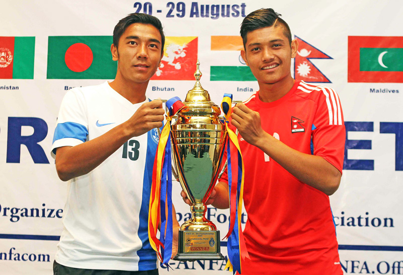 Nepal skipper Bimal Gharti Magar (right) and his Indian counterpart  Daniel Lalhlimpuia hold the first SAFF U-19 Championship trophy in Lalitpur on Friday. Photo: THT