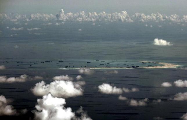 An aerial photo taken though a glass window of a Philippine military plane shows the alleged on-going land reclamation by China on mischief reef in the Spratly Islands in the South China Sea, west of Palawan, Philippines, May 11, 2015.  REUTERS/Ritchie B. Tongo/Pool