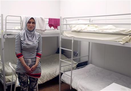 In this photo taken on Thursday, July 30, 2015, Syrian refugee Leila, no last name given, poses in an emergency shelter in Berlin where she waits with her family for her pending registration as asylum seekers. AP