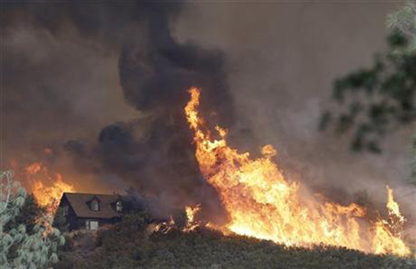 Fires approach a home near Lower Lake, Calif., Friday, July 31, 2015. A series of wildfires were intensified by dry vegetation, triple-digit temperatures and gusting winds. Photo:AP