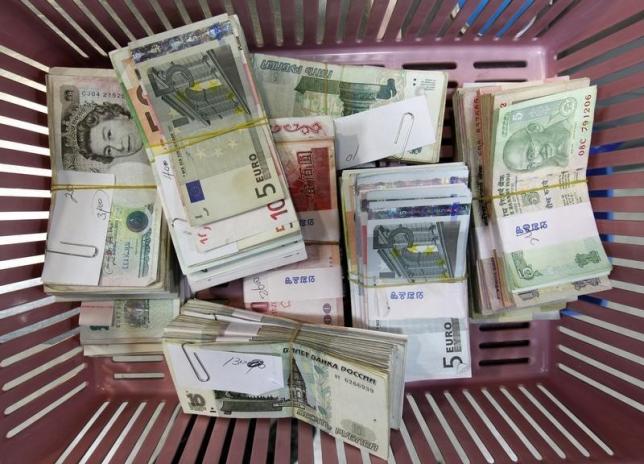 Foreign currency banknotes are placed on a basket for counting during a photo opportunity at the bank's headquarters in Seoul November 9, 2010.  REUTERS/Jo Yong-Hak