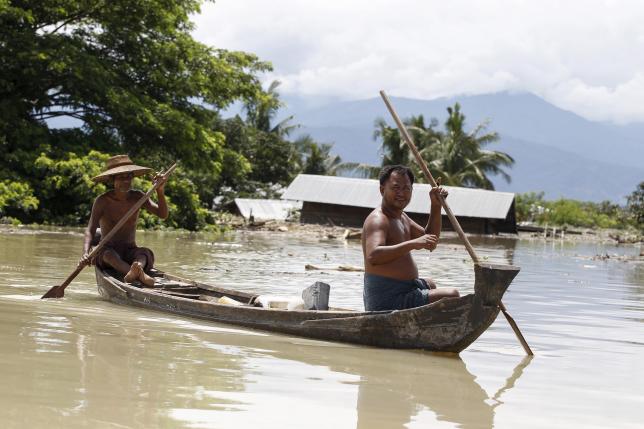 Men paddle their boat in a flooded village at Kalay township at Sagaing division, August 2, 2015. REUTERS/Soe Zeya Tun